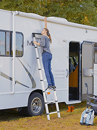 a woman is climbing a 2.6m telescoping roof tent ladder up to the top of rv