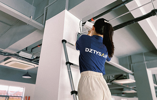 a girl climbs a telescopic aluminum ladder to fix the camera